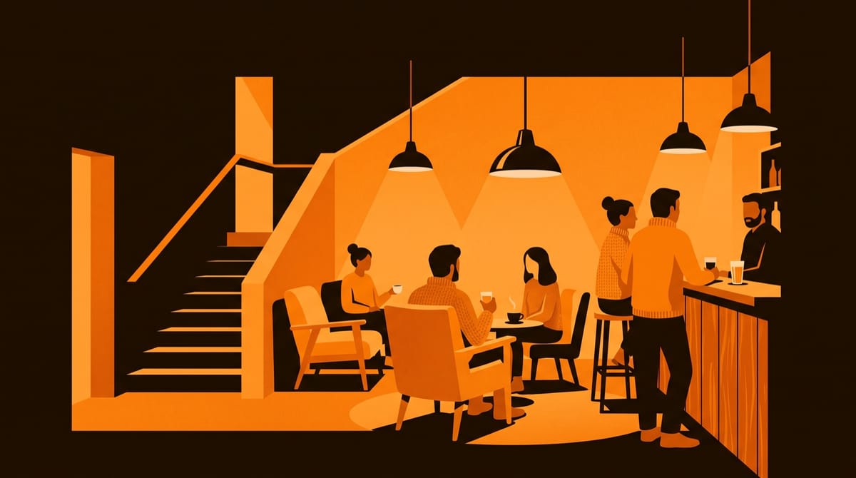 The small foyer of an independent arthouse cinema, seen from the entrance, with a wooden bar counter, mismatched armchairs and a handful of patrons in knitwear talking over drinks, seen from 