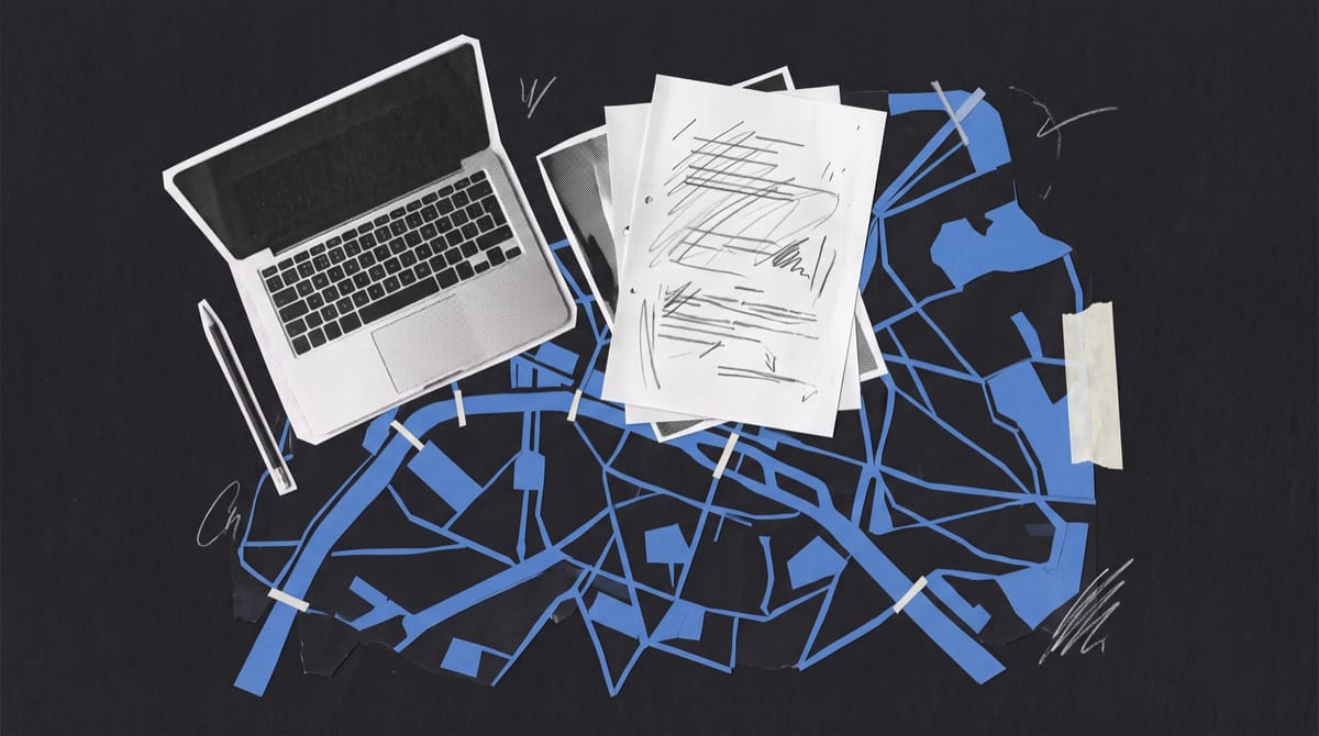 Paper collage of a desk seen from above, with a laptop, a pencil and marked-up screenplay pages laid over a blue cut-paper map of a river city.